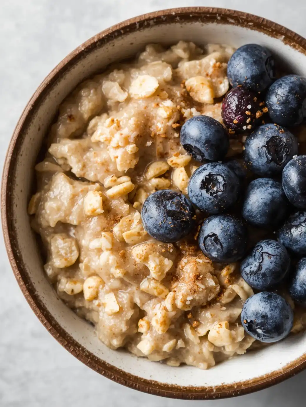 Steel-cut oats topped with fresh blueberries and a sprinkle of cinnamon.